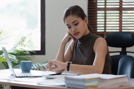 Asian accounting professional calculating household bills, reviewing and analyzing household bills, and filing tax returnsの写真素材