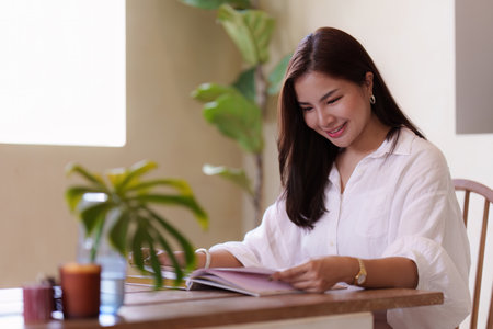 Attractive Asian woman resting comfortable living room and reading book, Relax, Sofa, Lifestyleの写真素材