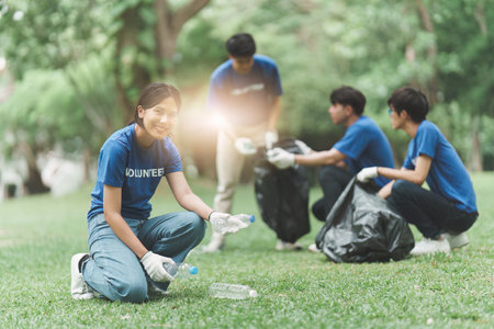 Young Asian Volunteers with garbage bags cleaning park area. Ecology, Charitable organization conceptの写真素材