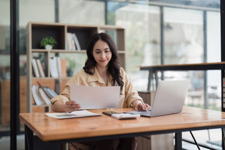 Accountant woman working on laptop and do document, tax, exchange, research, accounting and Financial advisor conceptの写真素材