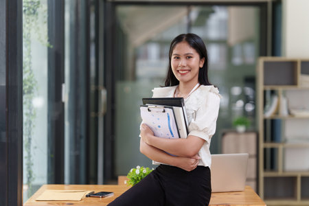 Financier a asian woman works, uses a laptop, makes a report to a finance company. Accounting and financial conceptの写真素材