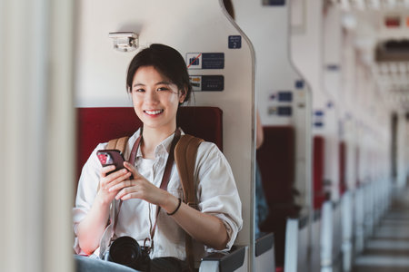 Asian Tourist person backpacker to travel at train station and using mobile phone. Tourism and...