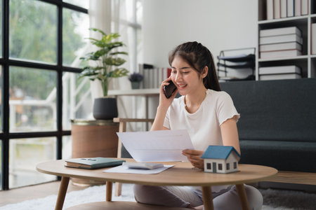 Asian accounting professional calculating household bills, reviewing and analyzing household bills, and filing tax returnsの写真素材