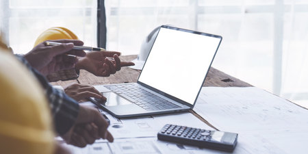 Architect and Engineer working with blueprints for architectural plan, engineer sketching a construction project, green energy conceptの写真素材