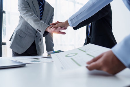 Group of business people putting their hands working together on wooden background in office. group...