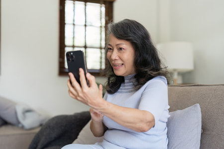 Elderly asian women using social media and living room. Video streaming, happiness and conversation...
