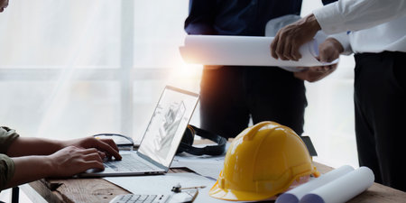 Architect and Engineer working with blueprints for architectural plan, engineer sketching a construction project, green energy conceptの写真素材
