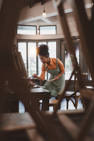 Beautiful american african artist woman painting in art studio at the university classroomの写真素材