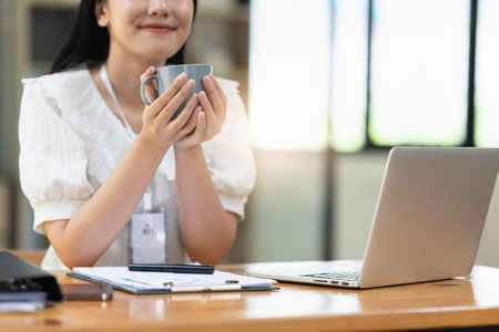 Financier a asian woman works, uses a laptop, makes a report to a finance company. Accounting and financial conceptの写真素材