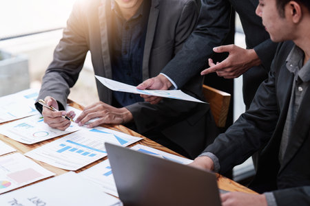 Close up of Diverse colleagues gather brainstorm discuss financial statistics at office meeting....