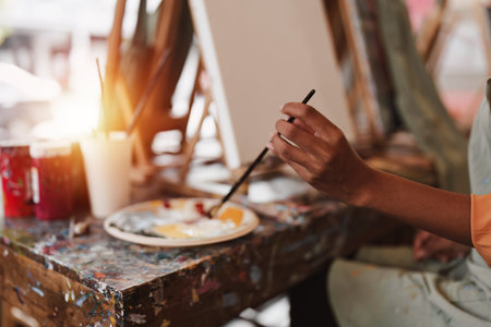 Beautiful American African artist woman painting in art studio at the university classroomの写真素材