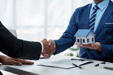 Real Estate agent and client handshake after sign contract and about home insurance and investment loanの写真素材