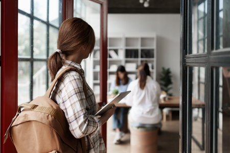 Close up of Young student with backpack carrying digital tablet in college. Student working at background. education, back to school conceptの写真素材