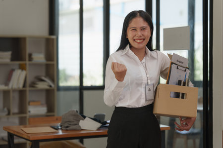 Resignation concept. Employee holding box of belongings in an office after resignation, Happy momentの写真素材