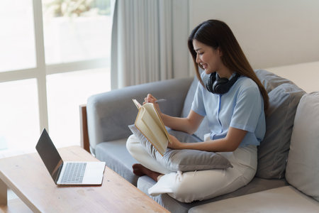 Attractive Asian woman resting comfortable living room and reading book, Relax, Sofa, Lifestyleの写真素材