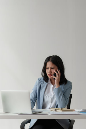Asian business woman feel stress with works, uses a laptop, makes a report to a finance company. Accounting and financial conceptの写真素材