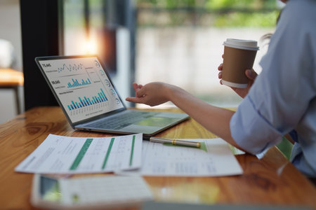 Financier a asian woman works, uses a laptop, makes a report to a finance company. Accounting and financial conceptの写真素材