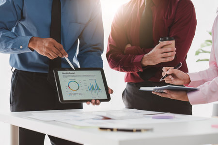 Close up of Diverse colleagues gather brainstorm discuss financial statistics at office meeting. finance, teamwork, Big data Graphs Charts conceptの写真素材