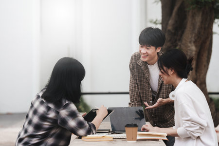 Beautiful young Asian people college student with friends at outdoors. College student working on the college campus.の写真素材