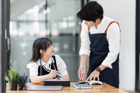 Young entrepreneur couple working on a tablet at cafe. Small business management conceptの写真素材