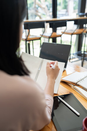 Asian students learn with a laptop and tutor at cafe