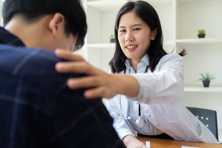 young woman Asian doctor patient, patting shoulder with care, support, sympathy, hope, giving comfort, empathy, asking about health patientの写真素材