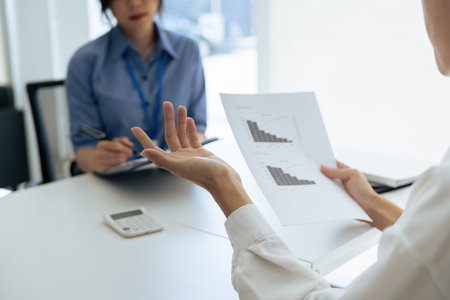 employee discuss business income report together in the officeの写真素材