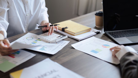 Teamwork of business people discuss and use calculator for finance paperwork data in office