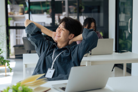 Happy business man stretching to relax from project. Worker, smile and hands behind head to finish tasks, rest and break at deskの写真素材