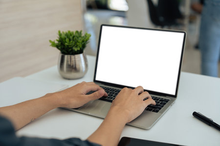 Closeup young businessperson sitting at desk and working on laptop. employee working at desk. blank screenの写真素材