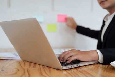 businessperson working on laptop and typing on keyboard at table in officeの写真素材