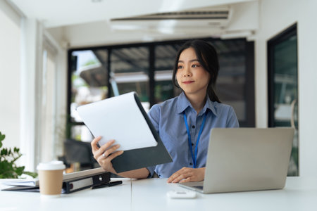 young businesswoman asian take notes at her desk in office.の写真素材