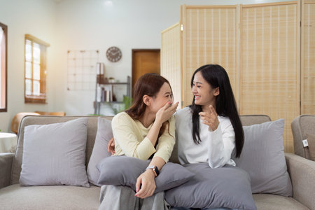 Asian lesbian woman couple enjoy watch TV together in house and feel happy watch movie on television. Homosexual-LGBTQ concept.の写真素材
