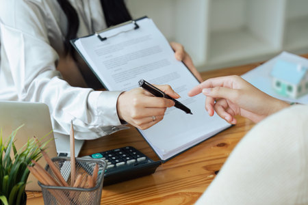 Real estate broker agent presenting and consult to customer to decision making sign insurance form...