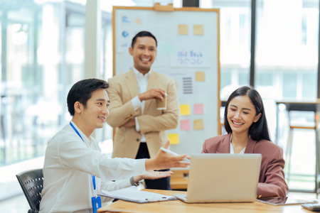 Business man advise colleague about finance report on calculamantor in officeの写真素材
