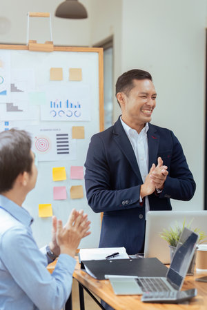 Business people meeting at office and applauding after successful presentation or successful strategizeの写真素材