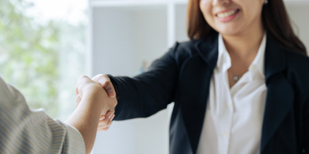 Two professional businesswoman executive leaders shaking hands at office meetingの写真素材