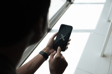 CHIANG MAI, THAILAND - July 28, 2023: Man holding a Apple iPhone with Twitter on the screen. Twitter is a social media online service for microblogging and networking communication.のeditorial素材