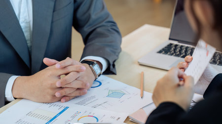 Close up focus on clasped hands of serious male entrepreneur holding negotiations meeting with partner in officeの写真素材