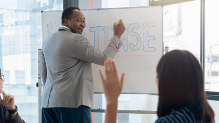 Happy African American male professor smile at student who raising arm to ask a question during...