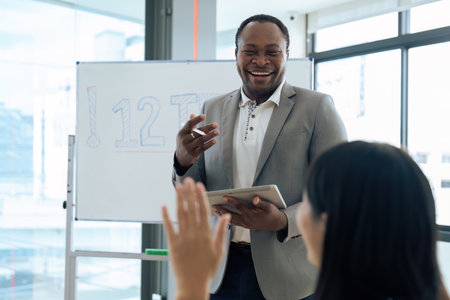 Mature african american professor talking to his student while teaching in class