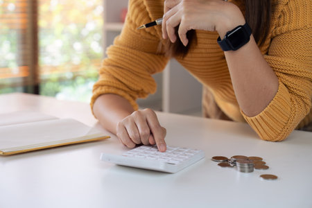 Stressed woman trying to deal with financial documents, having problem to find money to pay utility bills or loansの写真素材