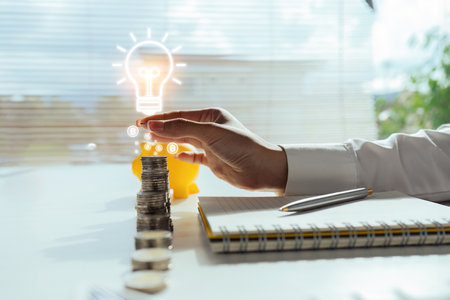 business accounting with saving money with hand holding lightbulb conceptの写真素材