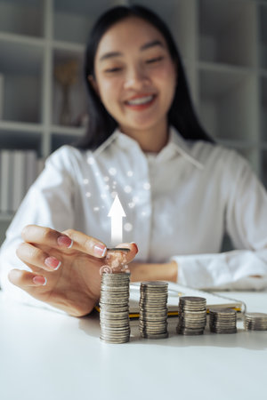 Woman hold coin and coins stack with white up arrow. Concept for invest and saving success in the future goalの写真素材