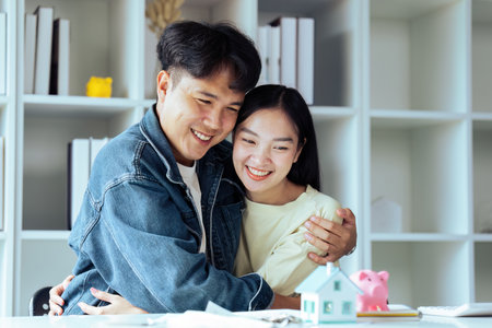 Young couple happy with successful completion of home loan contract, making financial plan to buy houseの写真素材