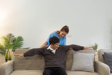 Asian female doctor advice elderly patient to physiotherapist to exercise at homeの写真素材