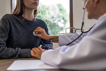 Doctor listens to heartbeat of patient middle age to check their heart rate