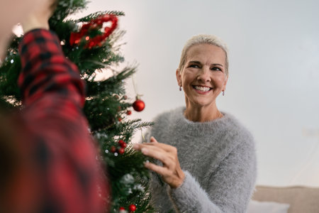 Daughter and mother caucasian decorate Christmas tree to prepare for familys Christmas Dayの写真素材