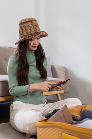 Happy Woman using smartphone booking vacation at travel agency or making hotel reservation onlineの写真素材