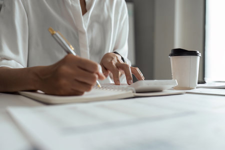 Woman accountant working with computer and calculator for business and financial expenseの写真素材